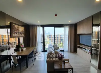 Spacious modern living room with large windows and city view, featuring elegant decor and dining area.