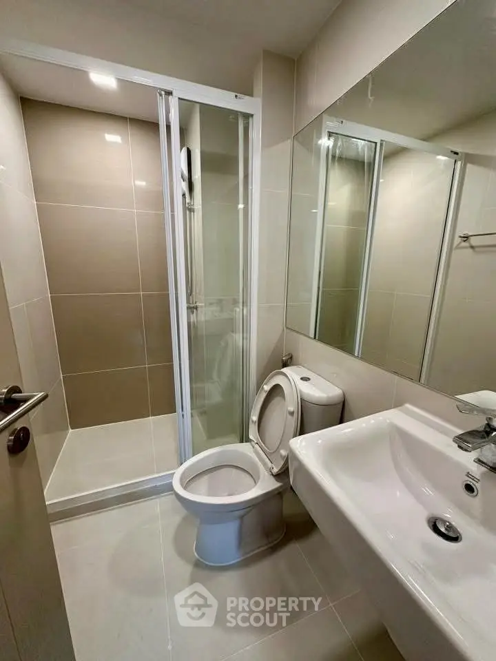 Modern bathroom with sleek shower and elegant fixtures in a contemporary apartment.