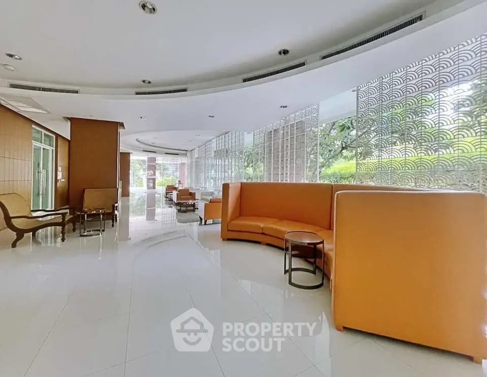 Luxurious lobby with modern seating and large windows offering garden views.