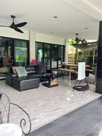 Spacious open-plan living area with modern furnishings and garden view, perfect for relaxation and entertaining.