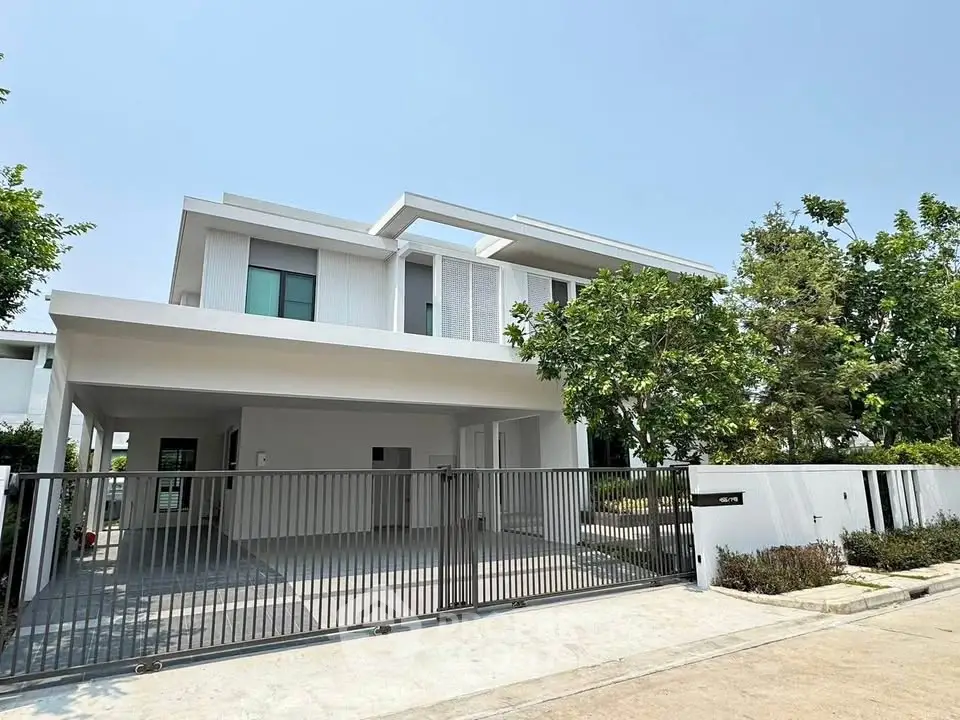 Modern two-story white house with sleek design and spacious driveway in a serene neighborhood.