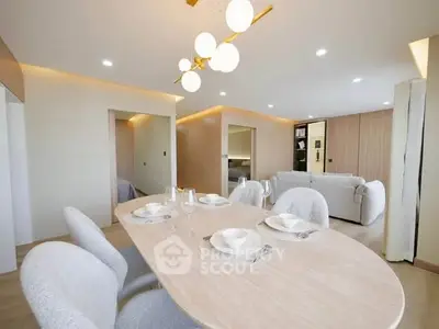 Elegant modern dining area with stylish lighting and cozy seating in a spacious open-plan living room.
