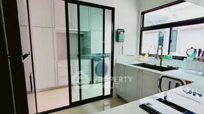 Modern kitchen with sleek design and integrated laundry area
