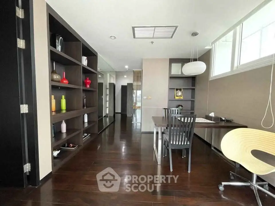 Modern study room with sleek wooden flooring and built-in shelves