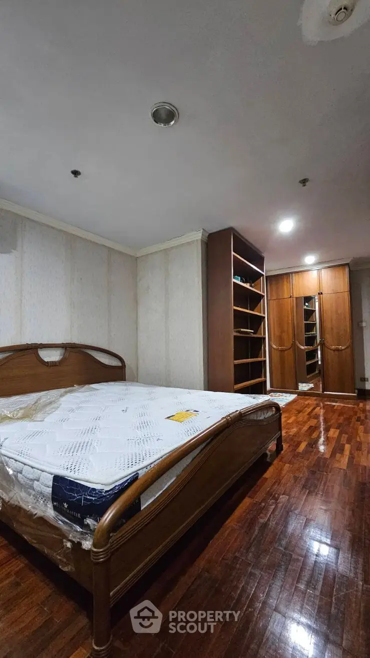 Spacious bedroom with wooden flooring and built-in wardrobe