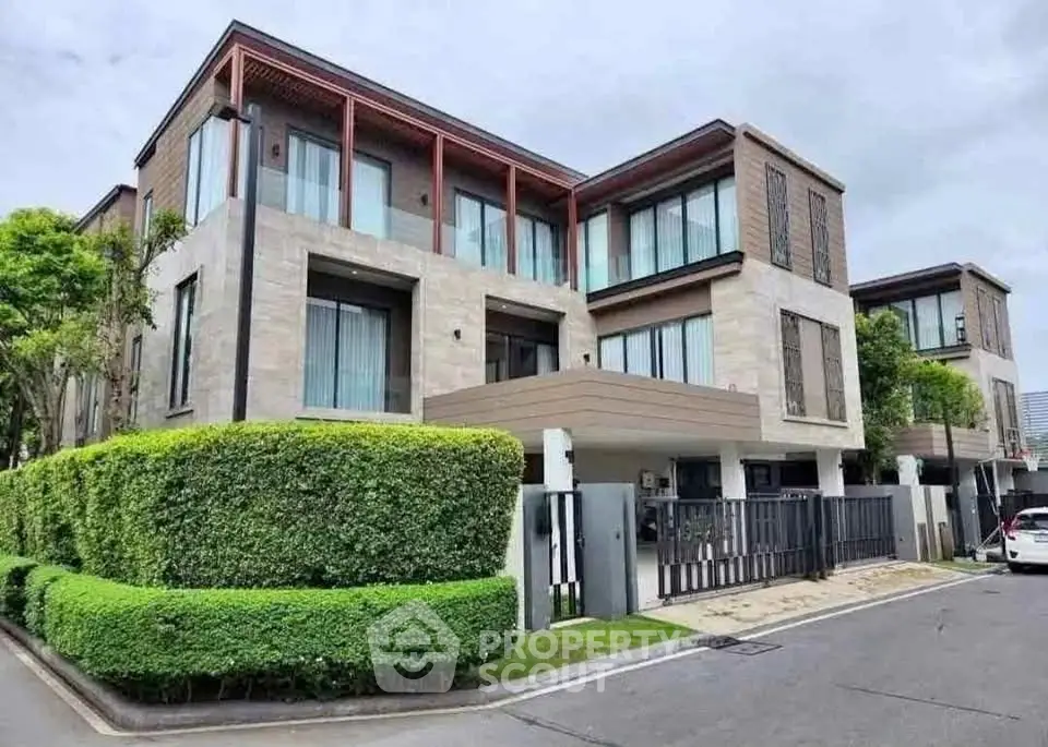 Modern luxury townhouse with sleek design and lush greenery in upscale neighborhood.