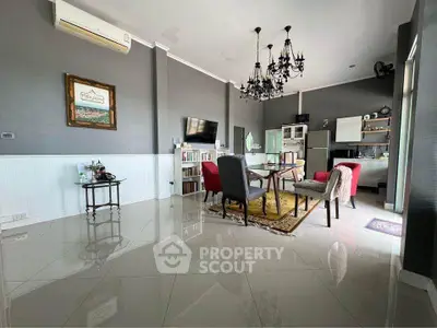 Spacious living room with elegant chandelier and modern kitchen in open layout