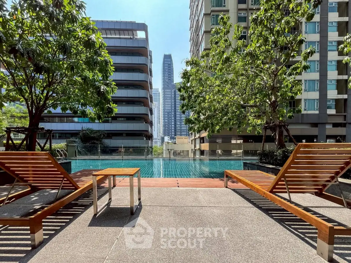 Luxurious urban poolside with modern high-rise view and lush greenery