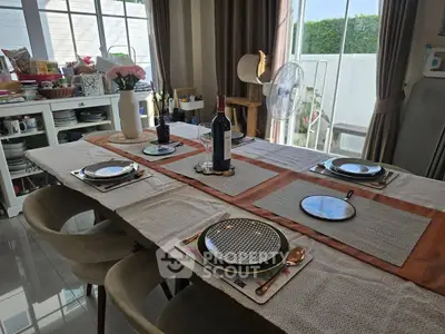 Elegant dining room setup with tableware and natural light, perfect for family gatherings.