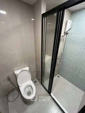 Modern bathroom with sleek shower and toilet in contemporary design.
