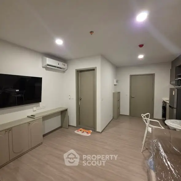 Modern living room with sleek design, featuring wall-mounted TV and air conditioning, perfect for comfortable living.