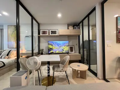 Modern living room with stylish decor and glass partitions, featuring a cozy seating area and wall-mounted TV.