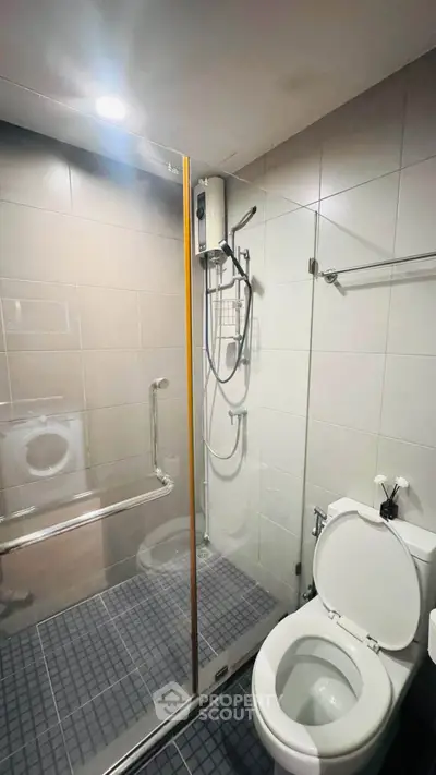 Modern bathroom with glass shower and sleek fixtures in contemporary apartment.