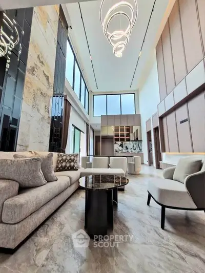 Luxurious modern living room with high ceilings and elegant lighting fixtures.