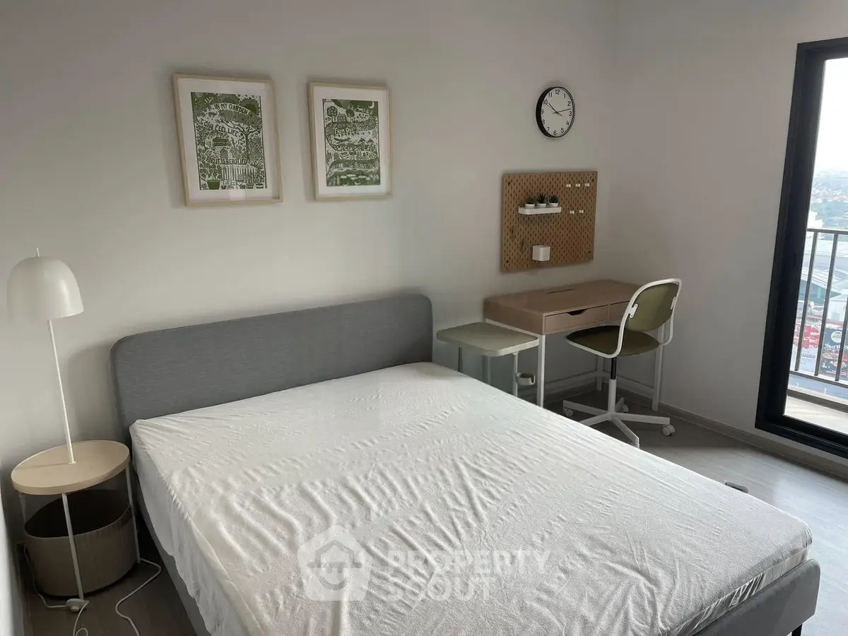 Modern bedroom with balcony view, stylish decor, and functional workspace.