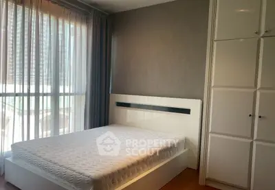 Modern bedroom with large window and built-in wardrobe, perfect for natural light lovers.