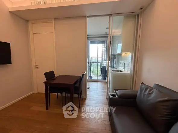 Modern living room with open kitchen and balcony view in a stylish apartment.