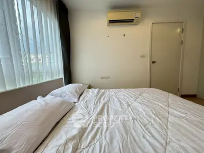 Cozy bedroom with air conditioning and large window for natural light