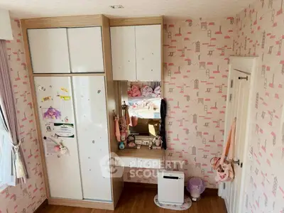 Charming children's bedroom with playful wallpaper and ample storage space