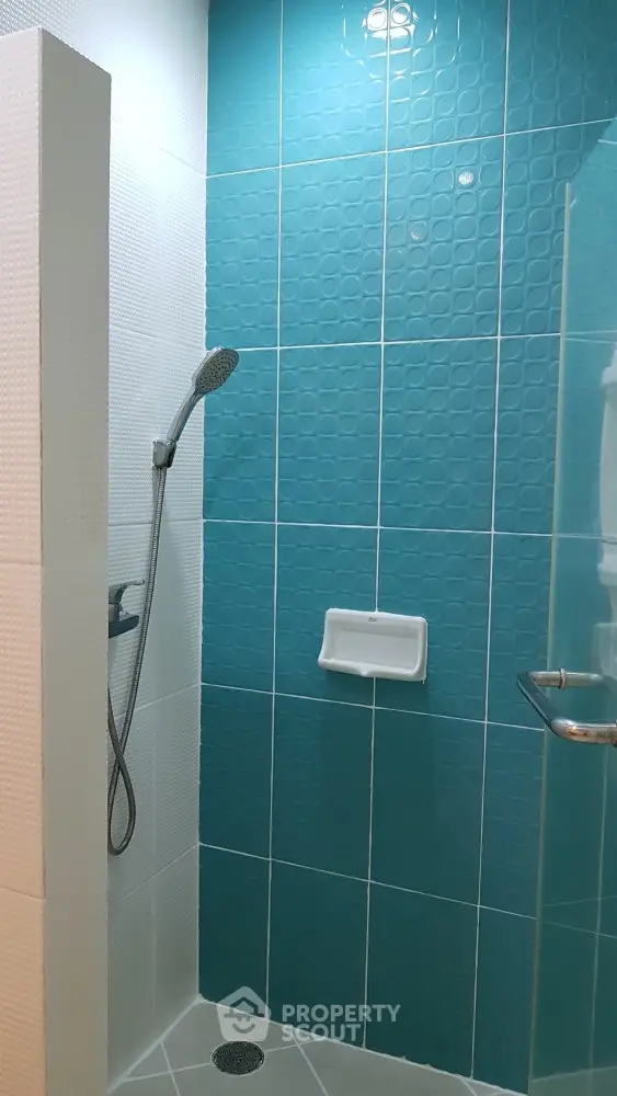 Modern bathroom with stylish blue tiles and sleek shower design