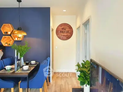 Modern dining area with stylish decor and vibrant blue accents in a cozy apartment.
