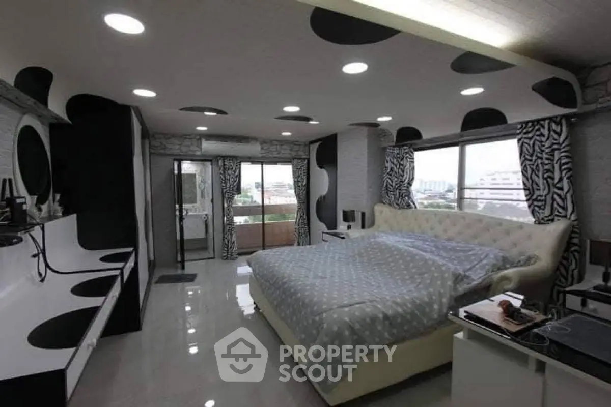 Stylish bedroom with modern decor and large windows offering city views.