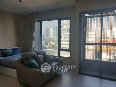Modern apartment with city view, featuring a cozy living area and large windows for natural light.