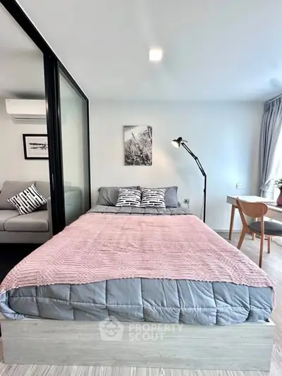 Modern bedroom with stylish decor and natural light, featuring a cozy bed and sleek furnishings.