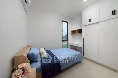 Modern minimalist bedroom with sleek storage and cozy single bed.