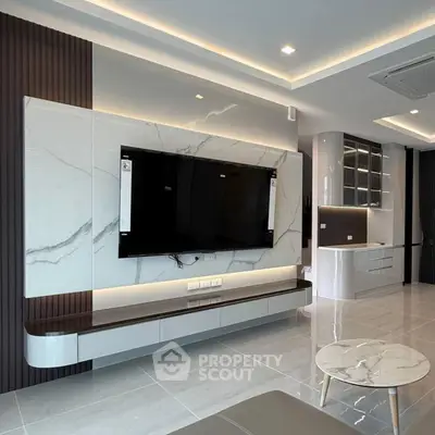 Modern living room with sleek marble TV wall and open kitchen layout