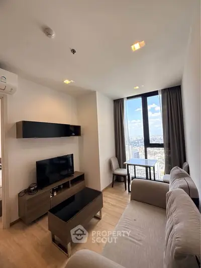 Modern living room with city view, featuring sleek furniture and large windows for natural light.