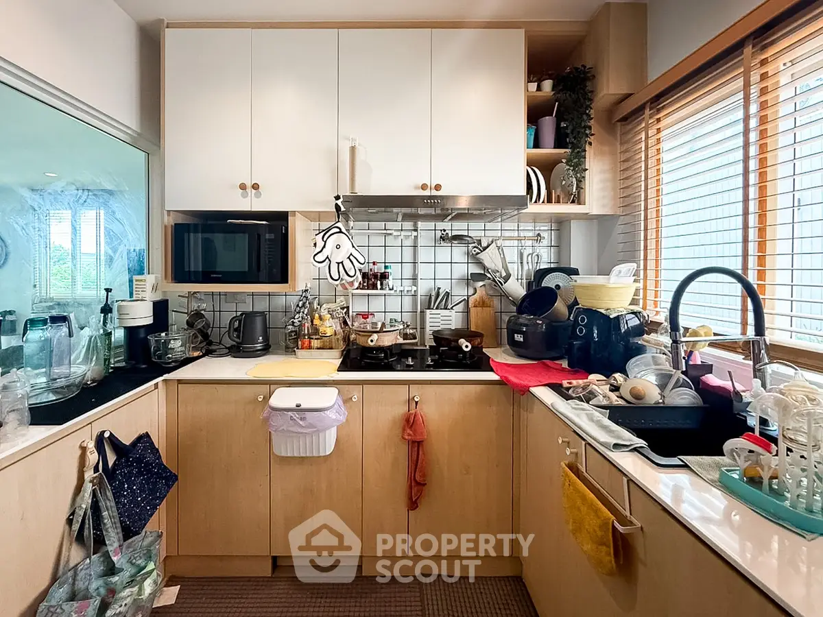Charming kitchen with gas stove and ample storage, featuring modern appliances and natural light.