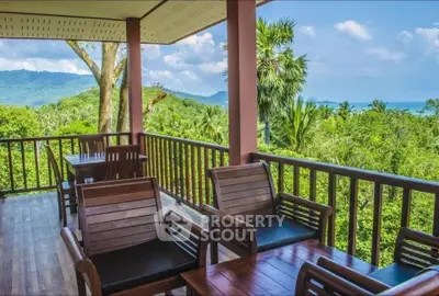 Stunning balcony with breathtaking tropical views and elegant wooden furniture.