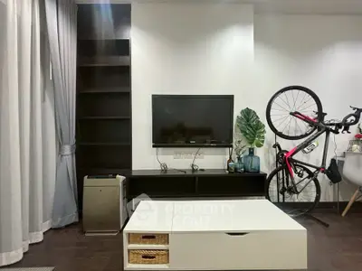 Modern living room with TV, bike storage, and sleek furniture in stylish apartment.