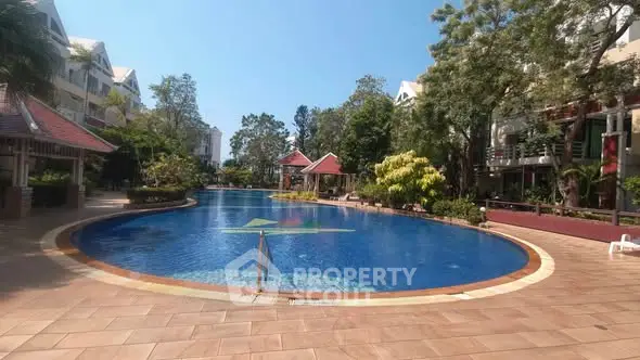 Luxurious residential pool area with lush greenery and modern architecture.