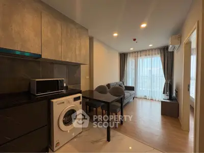 Modern apartment interior with open kitchen and living area, featuring washing machine and stylish decor.