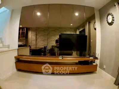 Modern living room with sleek TV unit and mirrored wall