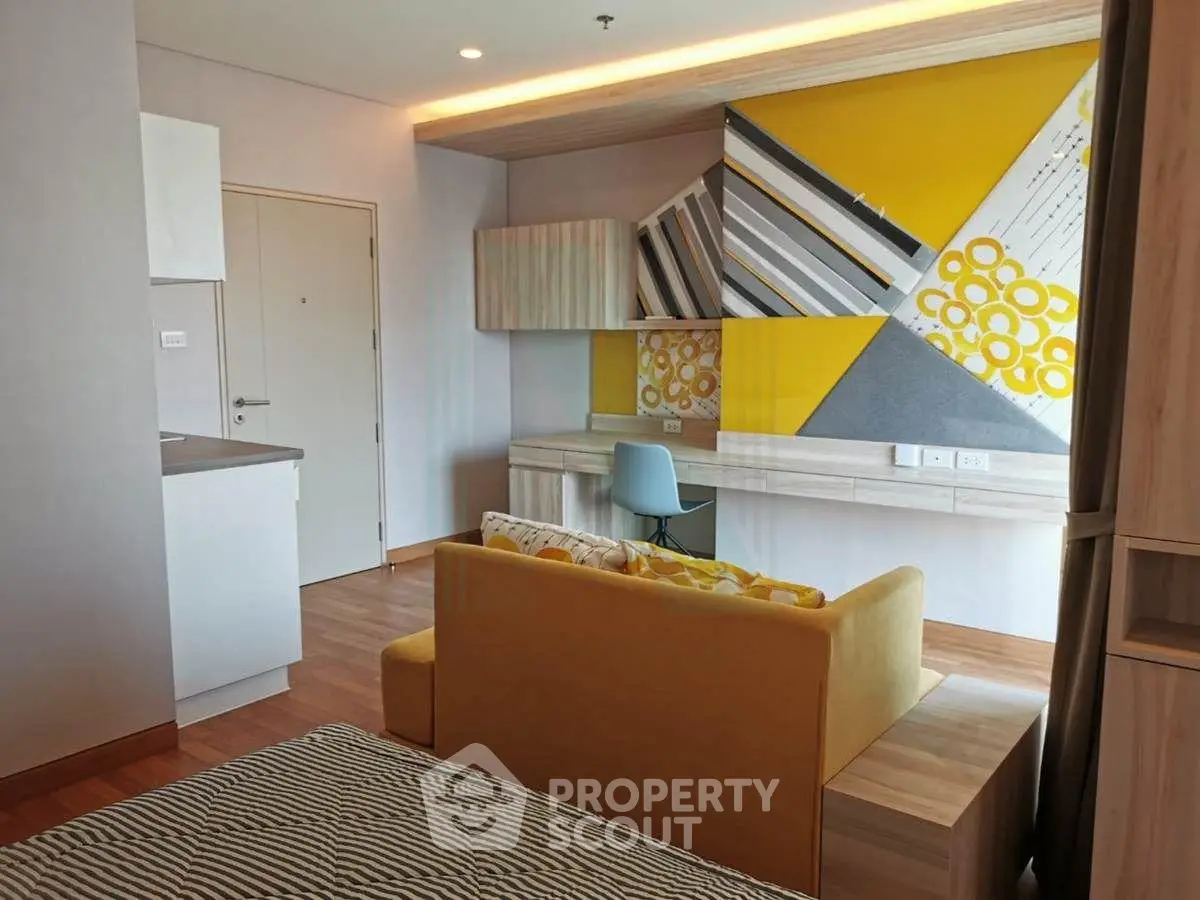 Modern studio apartment with stylish decor and compact layout, featuring a cozy living area and workspace.