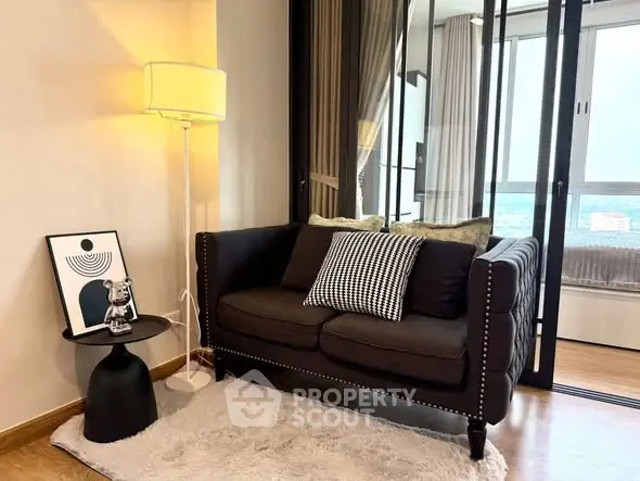 Cozy living room with stylish sofa and modern decor, featuring a floor lamp and a chic side table.