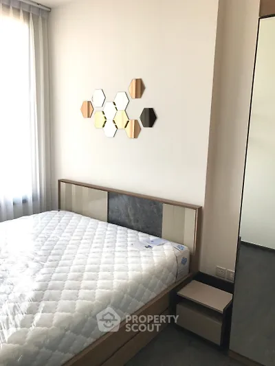 Modern bedroom with stylish hexagonal wall decor and natural light