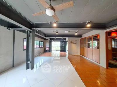 Spacious open-concept living area with modern ceiling fan and large windows