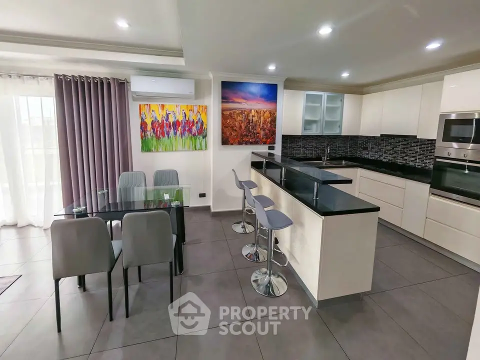Modern kitchen with sleek design, open layout, and stylish dining area, perfect for contemporary living.
