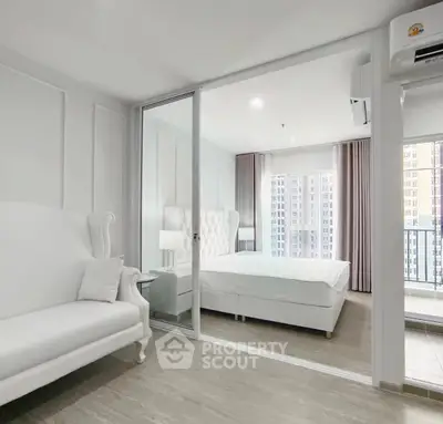 Modern bedroom with glass sliding doors and balcony view in a high-rise apartment.