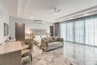Luxurious bedroom with marble flooring and elegant furnishings in a spacious layout.