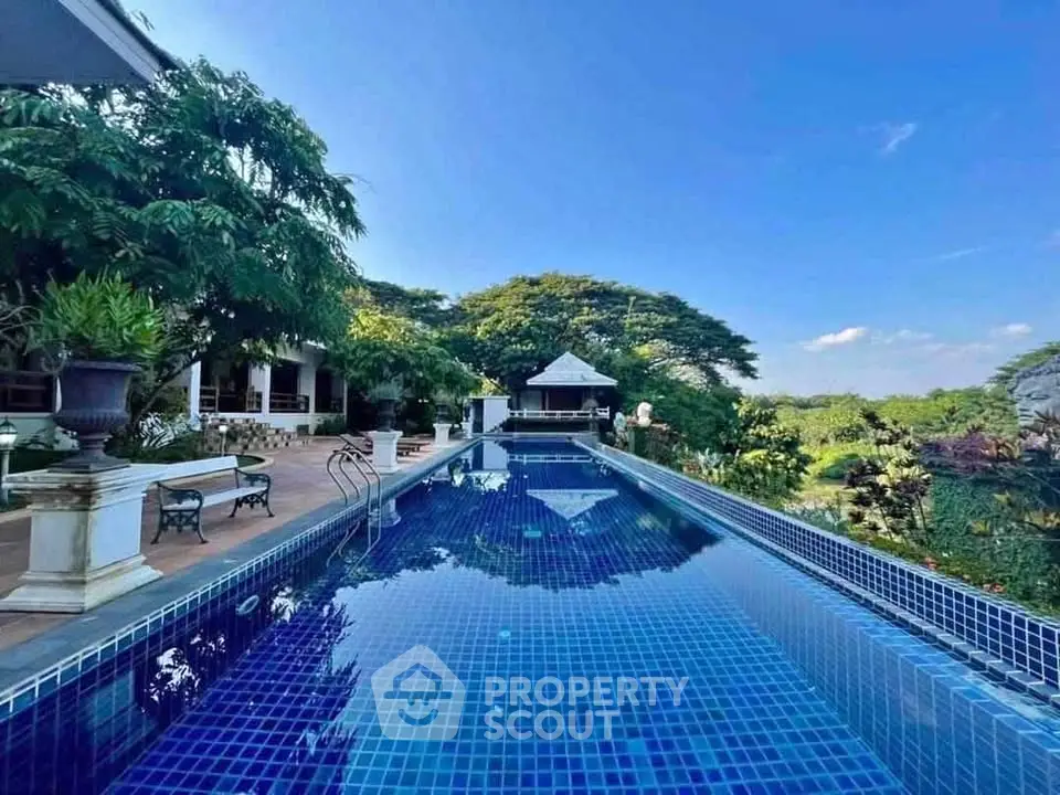 Luxurious outdoor pool with stunning garden view in a serene setting, perfect for relaxation and entertainment.