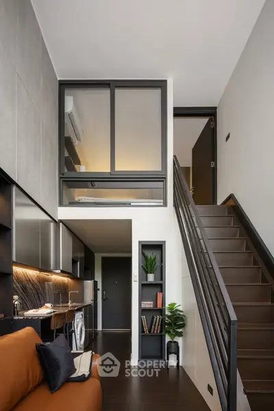 Modern loft apartment with stylish interior, featuring a cozy living area, sleek kitchen, and elegant staircase.