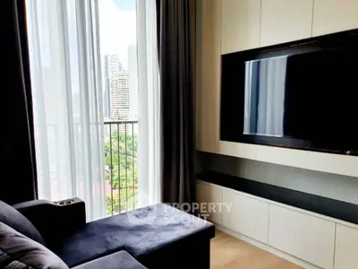 Modern living room with large TV and city view from balcony