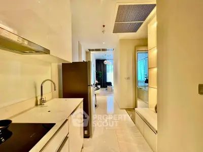 Modern kitchen with sleek design and open layout leading to a bright living area.