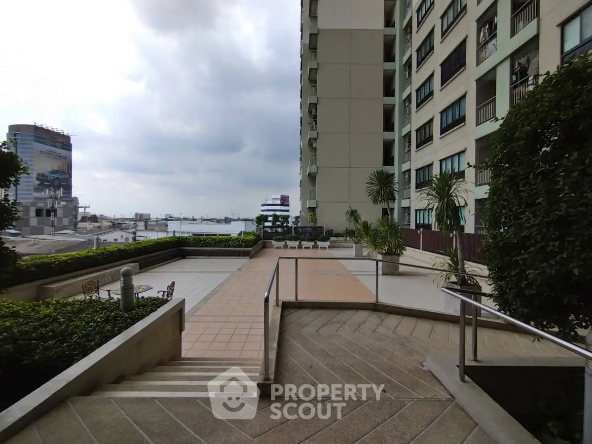 Spacious apartment building with scenic city view and lush greenery.