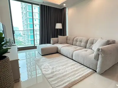 Modern living room with plush sofa and city view through large windows